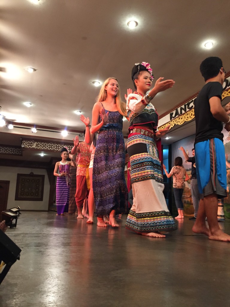 The group is invited to join a traditional dance at a local restaurant. 